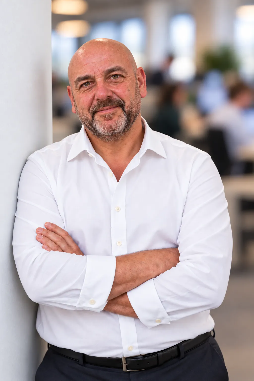 Portret mężczyzny z brodą, w białej koszuli, ze skrzyżowanymi rękami